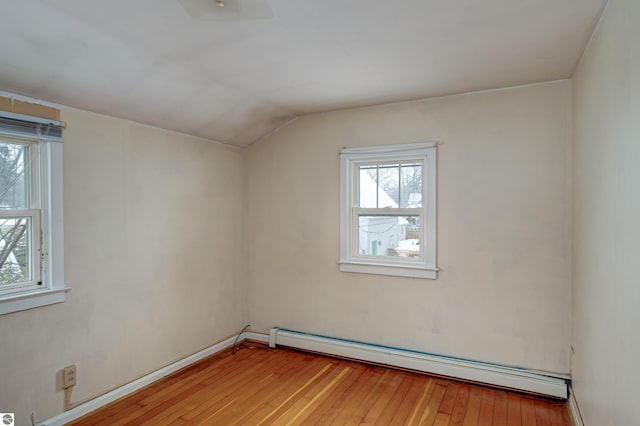 bonus room with light wood-type flooring, vaulted ceiling, and baseboard heating