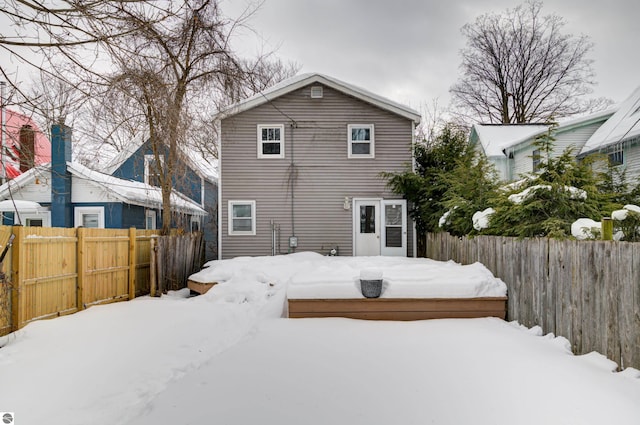 view of snow covered rear of property