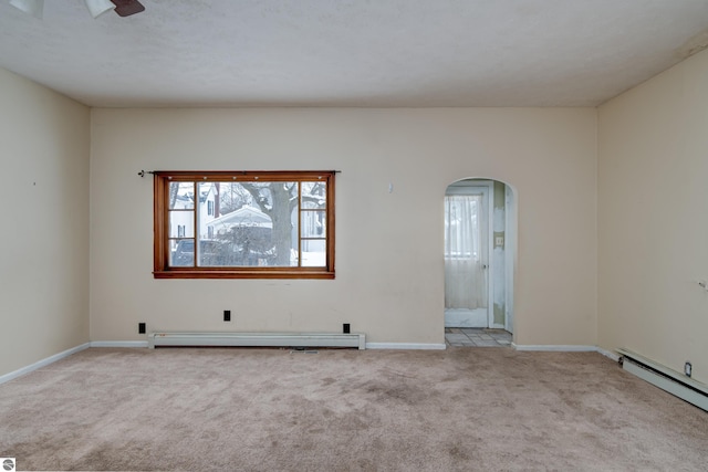 carpeted empty room featuring baseboard heating