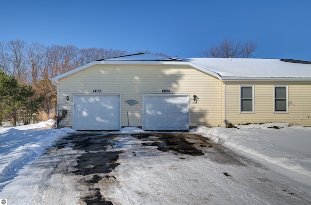 view of snowy exterior featuring a garage