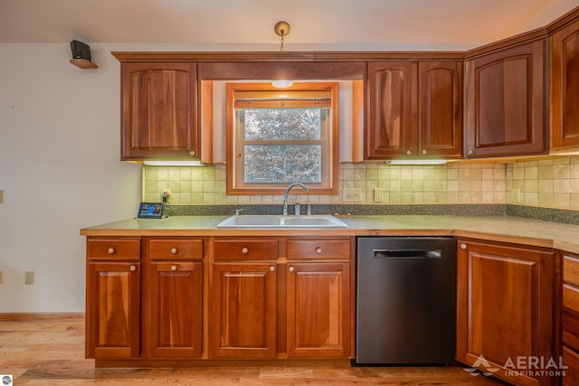 kitchen featuring decorative light fixtures, sink, backsplash, stainless steel dishwasher, and light hardwood / wood-style flooring