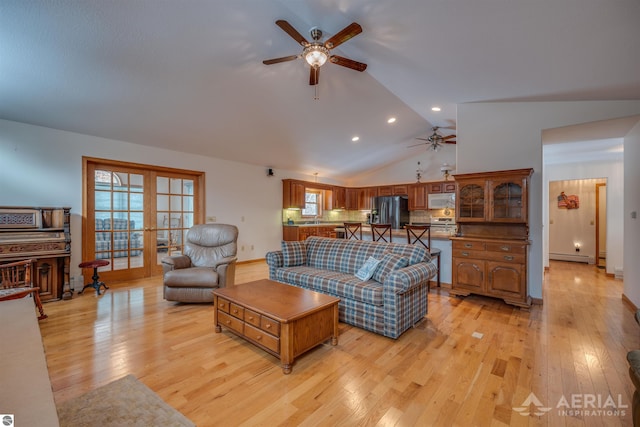 living room with vaulted ceiling, light wood-type flooring, and french doors