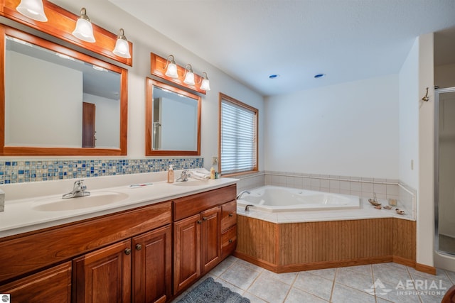 bathroom with tile patterned flooring, vanity, a bathtub, and backsplash