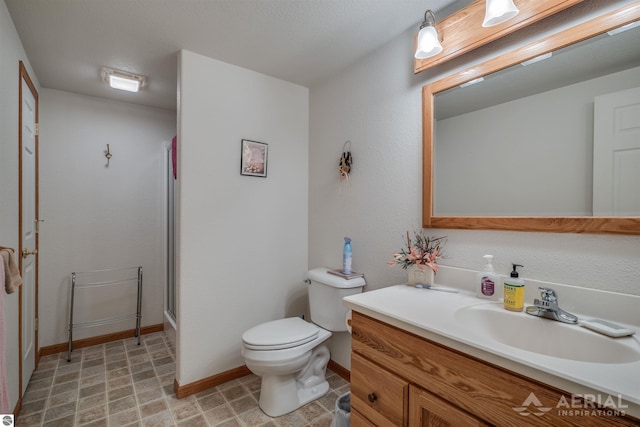 bathroom with vanity, walk in shower, and toilet