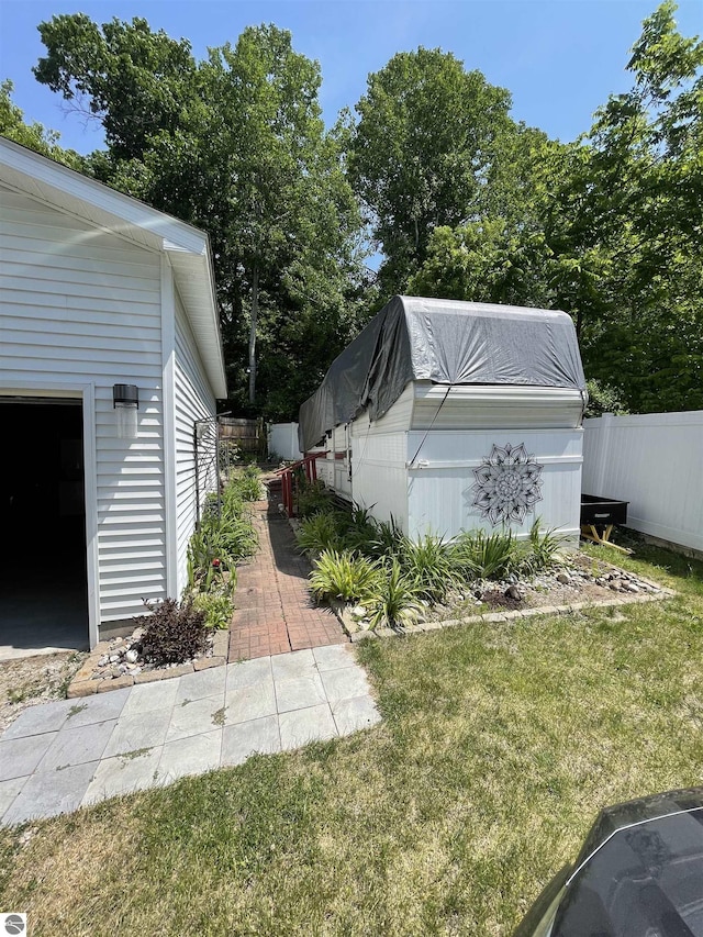 view of yard featuring a garage and an outdoor structure