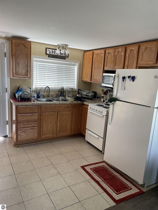 kitchen featuring sink, white appliances, and light tile patterned floors