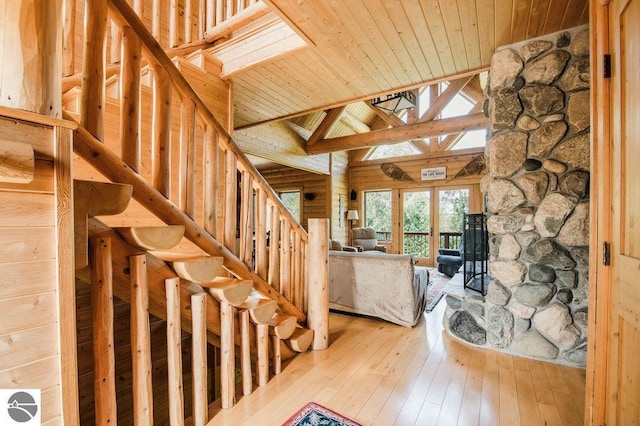 interior space featuring high vaulted ceiling, a skylight, wood-type flooring, wood ceiling, and beam ceiling