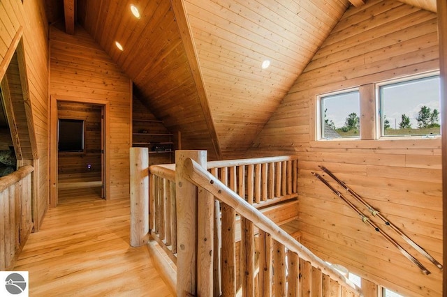 hall featuring vaulted ceiling, wooden ceiling, light hardwood / wood-style floors, and wood walls