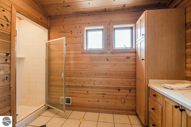 bathroom with walk in shower, wood walls, wooden ceiling, vanity, and tile patterned flooring