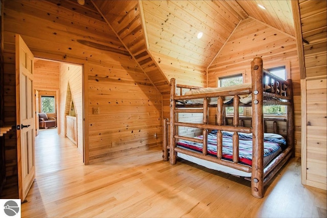 unfurnished bedroom featuring wood-type flooring, high vaulted ceiling, wood ceiling, and wood walls