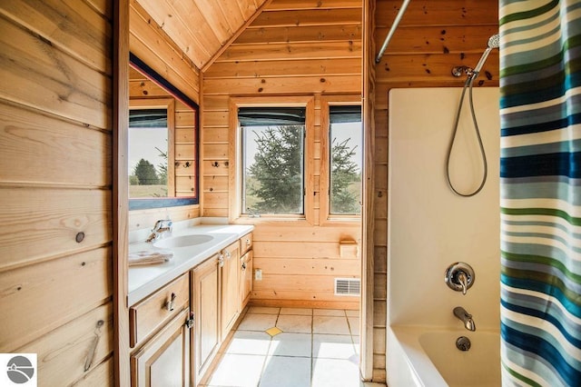 bathroom featuring vanity, lofted ceiling, tile patterned floors, and wooden walls