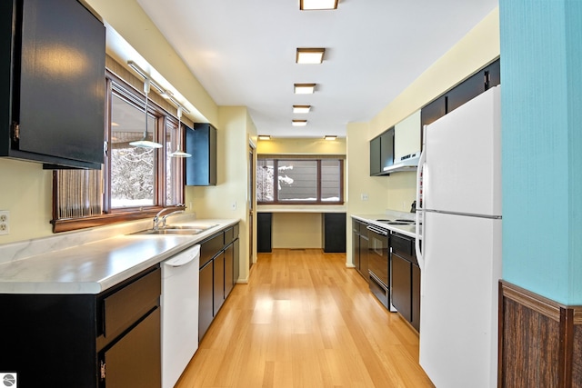 kitchen featuring white appliances, sink, and light wood-type flooring