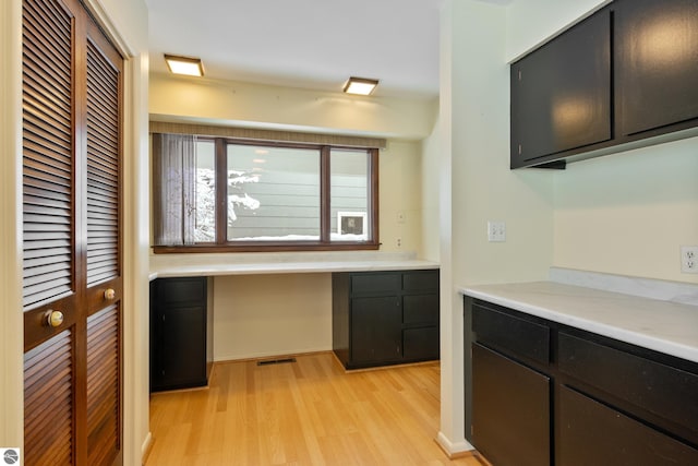 kitchen with built in desk and light wood-type flooring