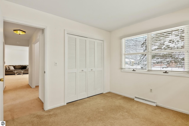 unfurnished bedroom with light colored carpet and a closet