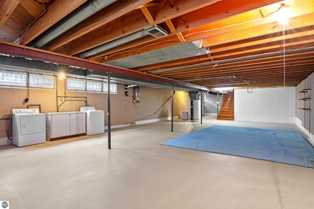 basement featuring electric panel, separate washer and dryer, and water heater