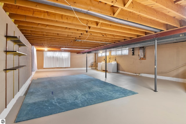 basement with electric panel and washer and clothes dryer