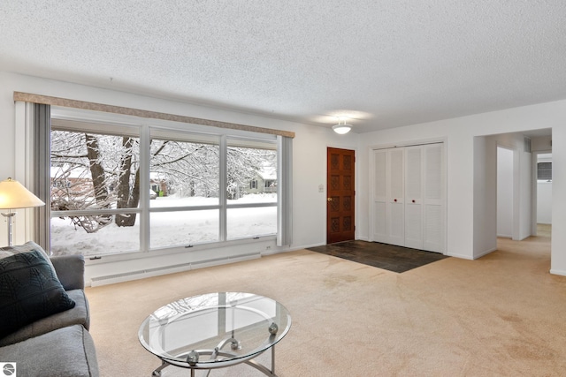 living room featuring light carpet, a baseboard heating unit, and a textured ceiling