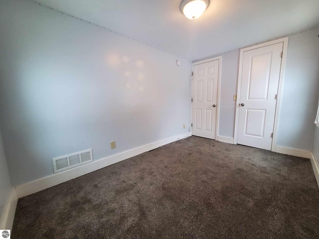 unfurnished bedroom featuring dark colored carpet