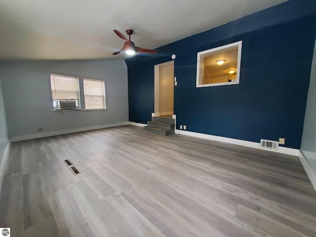 unfurnished room with hardwood / wood-style flooring, ceiling fan, vaulted ceiling, and cooling unit