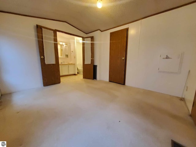 interior space with vaulted ceiling, ornamental molding, and a textured ceiling