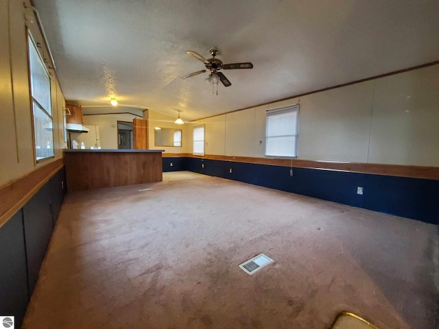 interior space with lofted ceiling, carpet floors, and ceiling fan