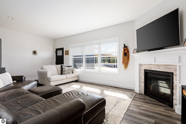 living room with dark hardwood / wood-style flooring and a fireplace