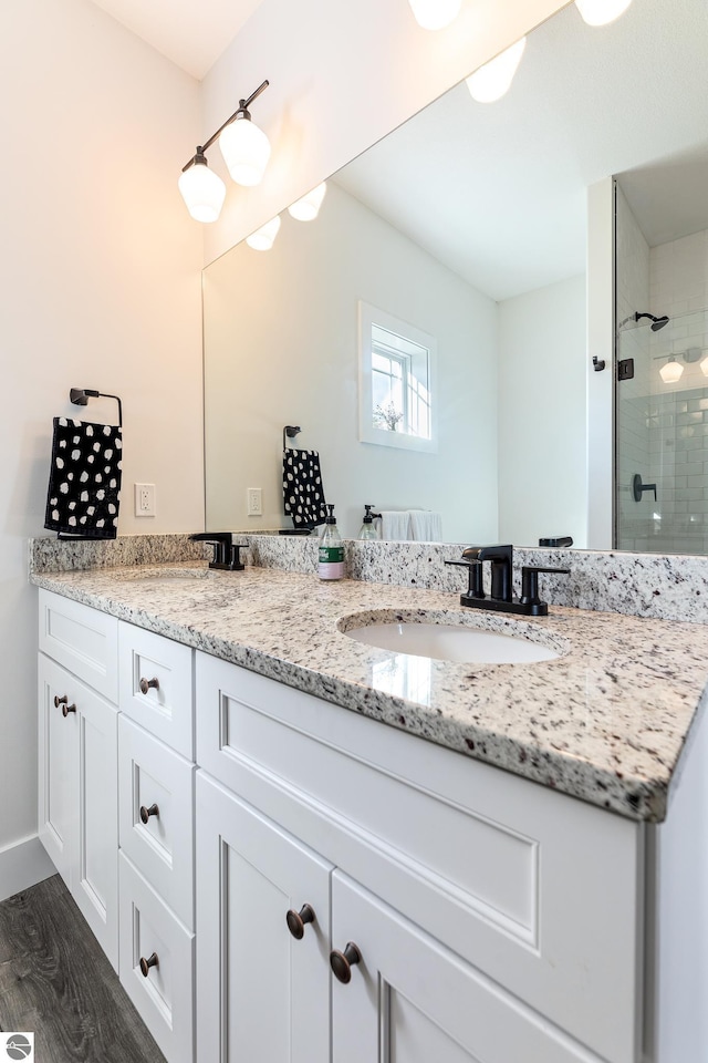 bathroom featuring tiled shower, vanity, and hardwood / wood-style floors