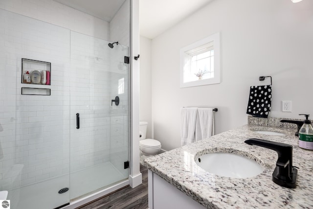 bathroom featuring vanity, hardwood / wood-style floors, an enclosed shower, and toilet