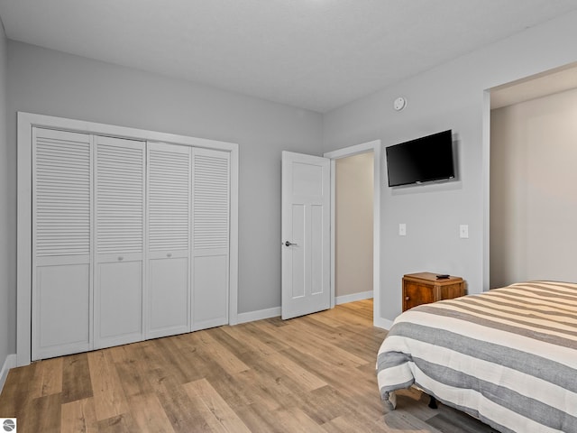 bedroom with light hardwood / wood-style flooring and a closet