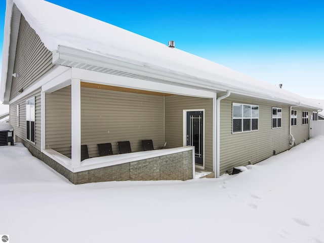 view of snow covered back of property