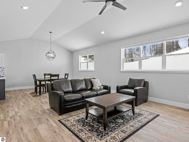 living room featuring ceiling fan, lofted ceiling, and light hardwood / wood-style floors