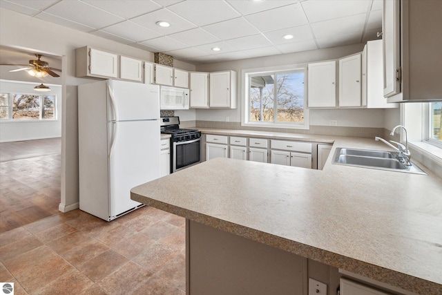 kitchen with white cabinetry, sink, white appliances, and kitchen peninsula