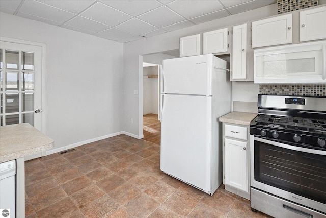 kitchen with a paneled ceiling, white cabinets, white appliances, and decorative backsplash