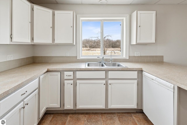 kitchen with white dishwasher, sink, and white cabinets