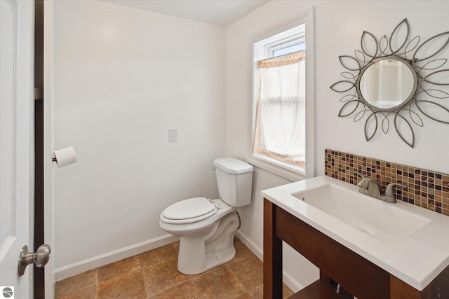 bathroom featuring vanity, toilet, and decorative backsplash