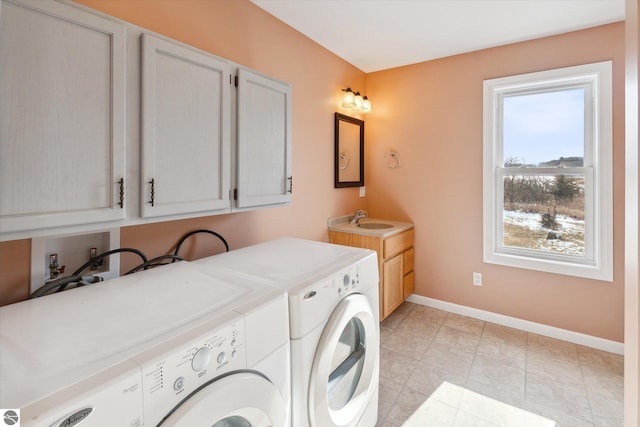 laundry area featuring cabinets, separate washer and dryer, and sink