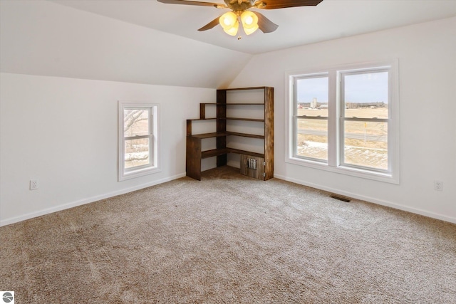 additional living space with carpet floors, ceiling fan, and vaulted ceiling