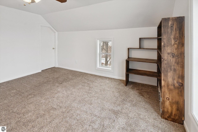 bonus room with lofted ceiling, ceiling fan, and carpet flooring