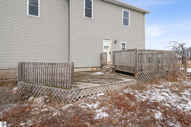 snow covered rear of property with a deck