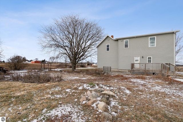 snow covered rear of property featuring a wooden deck