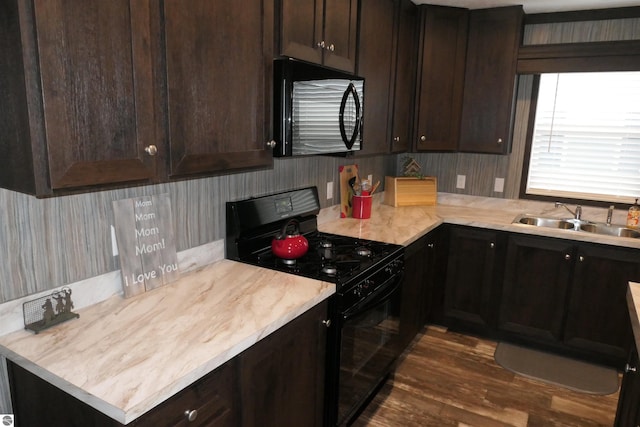 kitchen featuring sink, dark brown cabinets, and black appliances