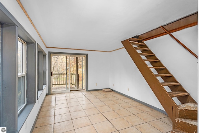 tiled spare room featuring ornamental molding