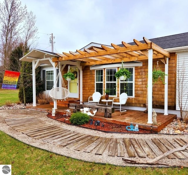 back of house featuring a wooden deck and a pergola