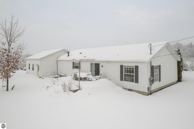 view of snow covered back of property