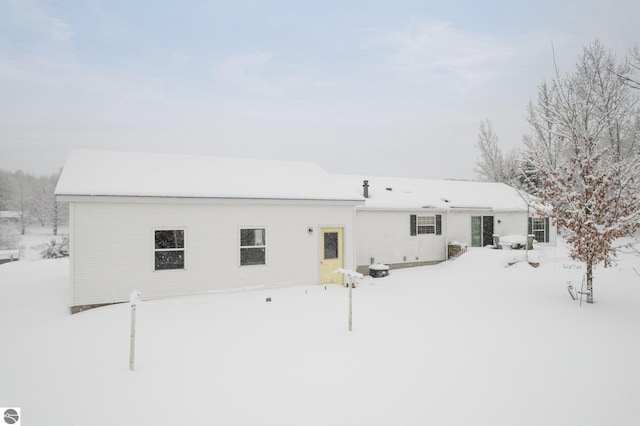 view of snow covered rear of property