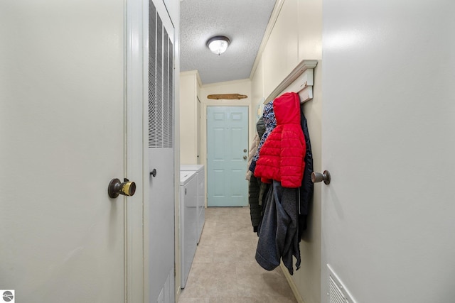 hall featuring washer and clothes dryer and a textured ceiling