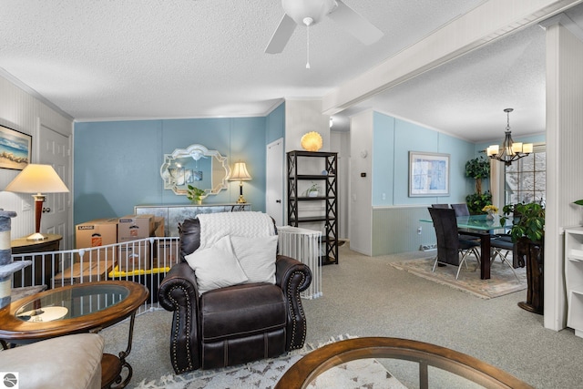 carpeted living room with beam ceiling, ornamental molding, ceiling fan with notable chandelier, and a textured ceiling