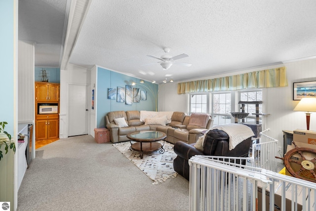 carpeted living room featuring ceiling fan and a textured ceiling