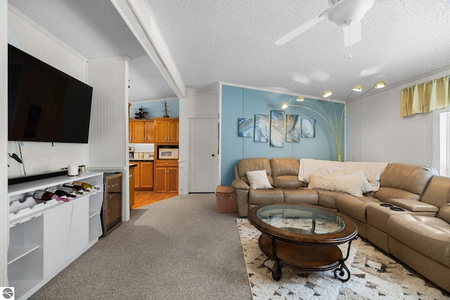 carpeted living room featuring crown molding, ceiling fan, and a textured ceiling