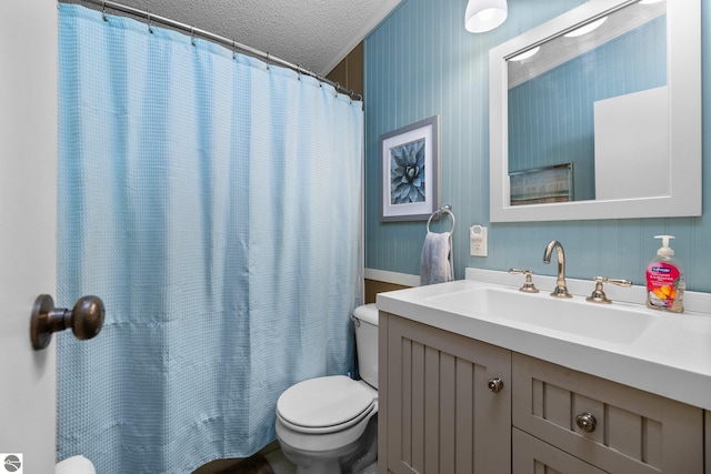 bathroom with vanity, curtained shower, toilet, and a textured ceiling